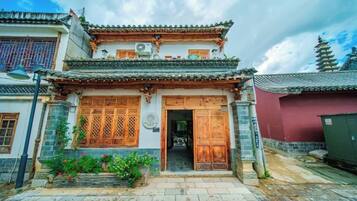 Un edificio tradicional chino con puerta de madera, tejado de tejas y base de piedra.
