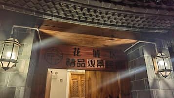 Une entrée de style architectural chinois traditionnel, avec une porte en bois et des murs en pierre.