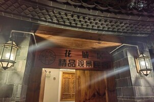 Una entrada de arquitectura tradicional china con puerta de madera y muros de piedra.