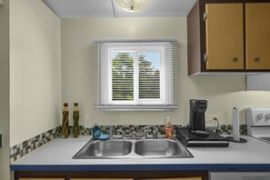 A kitchen with a double sink, a window with blinds, a coffee maker, and a toaster. - Pet friendly, hdtv°Fireplace°Netflix°Backyard (Deep gap)