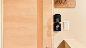 A wooden door with a number plate '202' and a wall-mounted intercom and light switch. - Tabitime tengachaya  (Osaka)