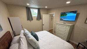 A bedroom with a bed, a dresser, a television, and a door. - Pool Table, Hot Tub! 5 bedroom, 3 bath, 5 min to Cal Poly or Old Town. (Eureka)