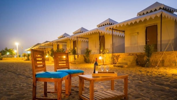 A row of tents with a table and chairs in the foreground. - Ozaki Desert Camp Jaisalmer (Jaisalmer)