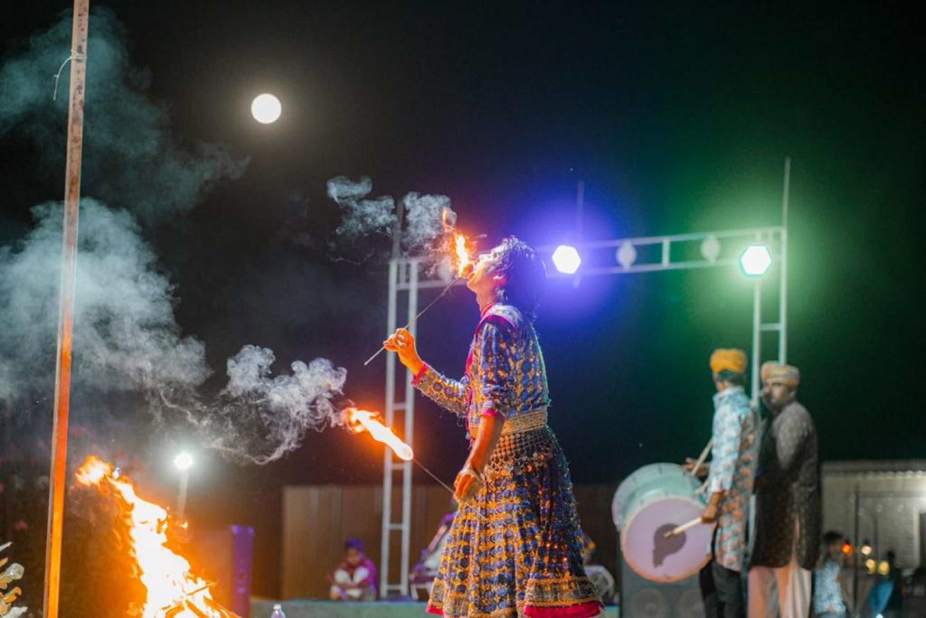 A person performing with fire in a traditional outfit.