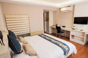 A hotel room with a bed, a desk, a chair, a TV, and a wardrobe. - Carlos Hotel (Kaiping Dongjiao Store) (Kaiping)