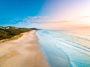 Un paysage côtier avec une plage de sable et des vagues de l’océan.