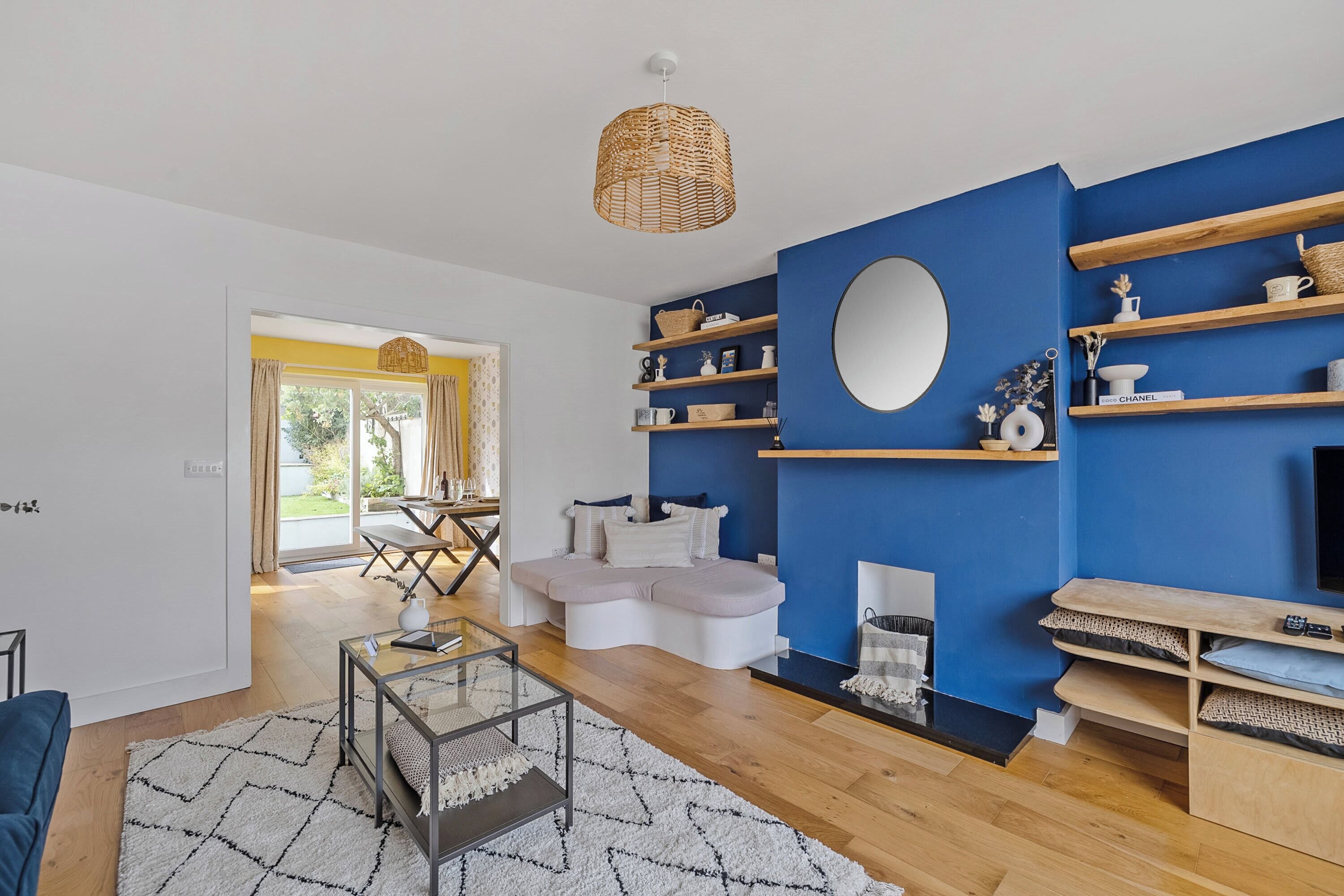 A modern living room with a sofa, coffee table, and a TV stand.