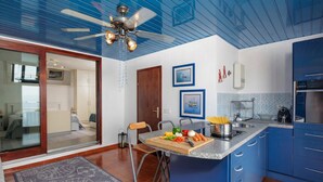 Una cocina moderna con armarios azules, una isla de madera y un ventilador de techo.