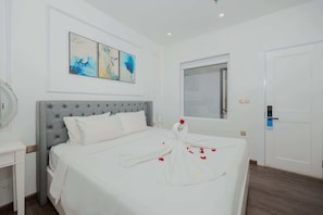 Ein Hotelzimmer mit Bett, Nachttisch, Spiegel, Fenster und Wandbild.