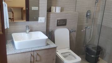 Un baño con lavamanos, inodoro y ducha.