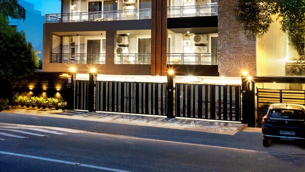 A multi-story building with balconies, large windows, and a gated entrance. - Perch Arbor Cyber City (Gurugram)