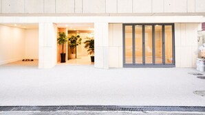 Een moderne hotelentree met een strak design, met een opvallend logo en de naam 'HOTEL Simplesay'.