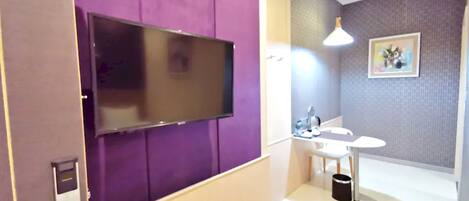 A modern bathroom with a large mirror, a sink, and a toilet.