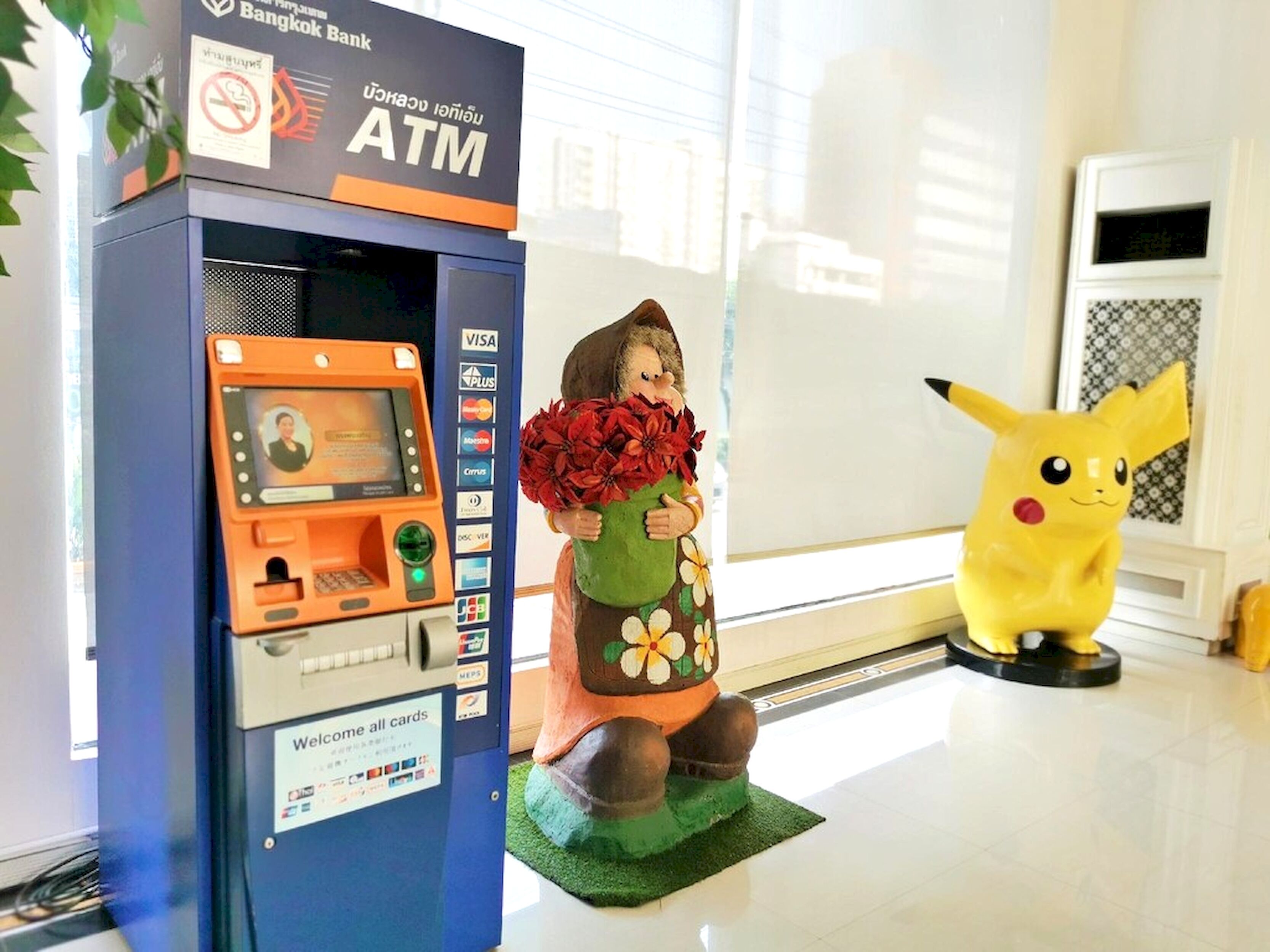 An ATM machine with a sign indicating it is a Bangkok Bank ATM.
