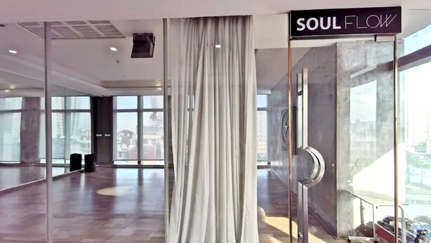 A spacious room with a large window, a curtain, and a sign that reads "SOUL FLOW".