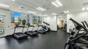 A gym with treadmills, exercise bikes, and a large window offering a city view. - Brickell Bay View Oasis with Pool, Hot Tub, & Gym (Miami)