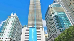 A tall, modern building with a prominent blue vertical stripe. - Brickell Bay View Oasis with Pool, Hot Tub, & Gym (Miami)