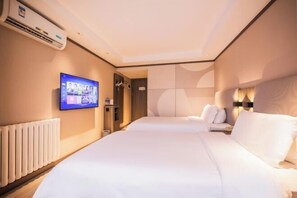 Ein Hotelzimmer mit einem großen Bett, einem an der Wand befestigten Fernseher und einer Heizung.