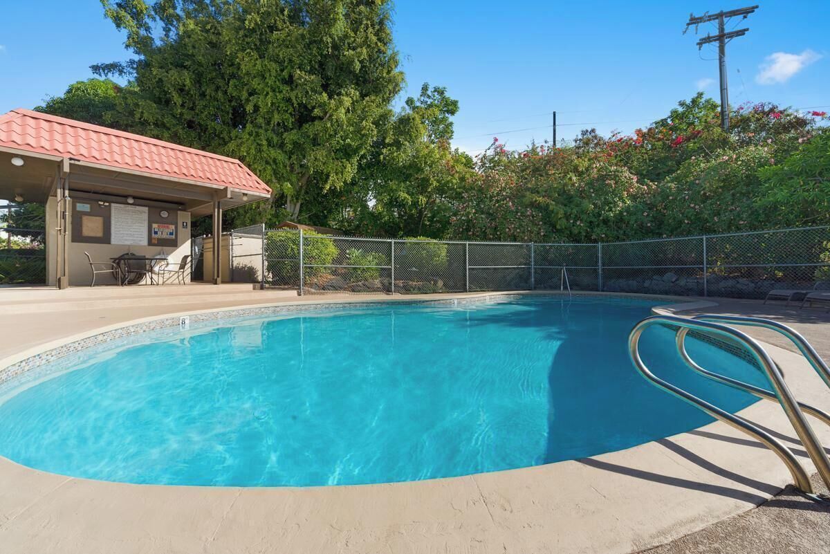 A swimming pool with a covered area and a fence.