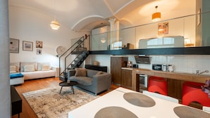 A modern interior with a staircase, a kitchen, a dining area, and a living room.