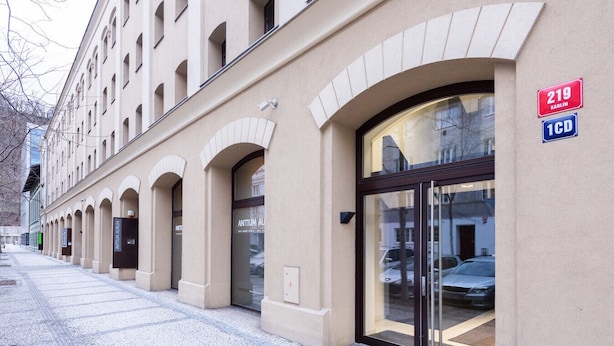 A building with arched windows and a large glass entrance door, labeled with the number 219.