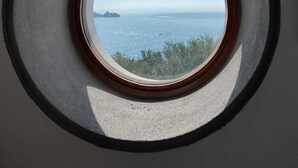 Un tragaluz con vista al mar y a la costa lejana.
