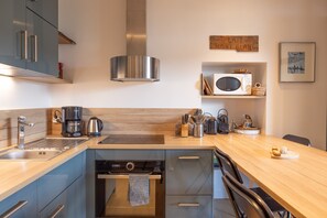 A modern kitchen with stainless steel appliances, a microwave, and a coffee maker.