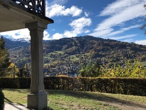 A stone structure with a view of a town and mountains in the background.