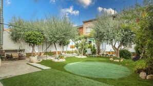 A well-maintained garden with a lawn, trees, and a small pool area. - Holiday Home 'Cal Marcos' with Private Terrace, Private Garden and Wi-Fi (Torregrossa)