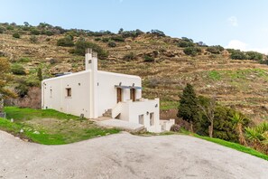 Un edificio blanco con una pequeña escalera, una puerta y una ventana.