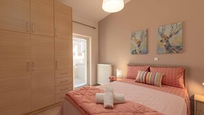 Une chambre à coucher comprenant un lit, une armoire et deux tableaux accrochés au mur.