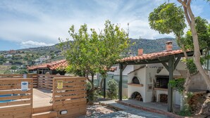 A courtyard with a wooden deck, stone flooring, and a building with a tiled roof. - Holiday Home 'Villa Melenia 1' with Private Pool, 5 Minutes from the Beach, Wi-Fi & Air Conditioning (??. ?e?a??a)