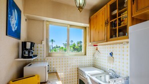 A compact kitchen with a window, a toaster, a small refrigerator, and a sink. - Apartment "T2 a 50 m Plage du Midi" with Shared Terrace & Wi-Fi (Cannes)