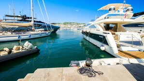 A marina with several yachts docked, a small inflatable boat, and a Yamaha outboard motor on a dock. - Apartment "T2 a 50 m Plage du Midi" with Shared Terrace & Wi-Fi (Cannes)