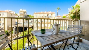 A balcony with a table, a bench, a teapot, and a green mug. - Apartment "T2 a 50 m Plage du Midi" with Shared Terrace & Wi-Fi (Cannes)