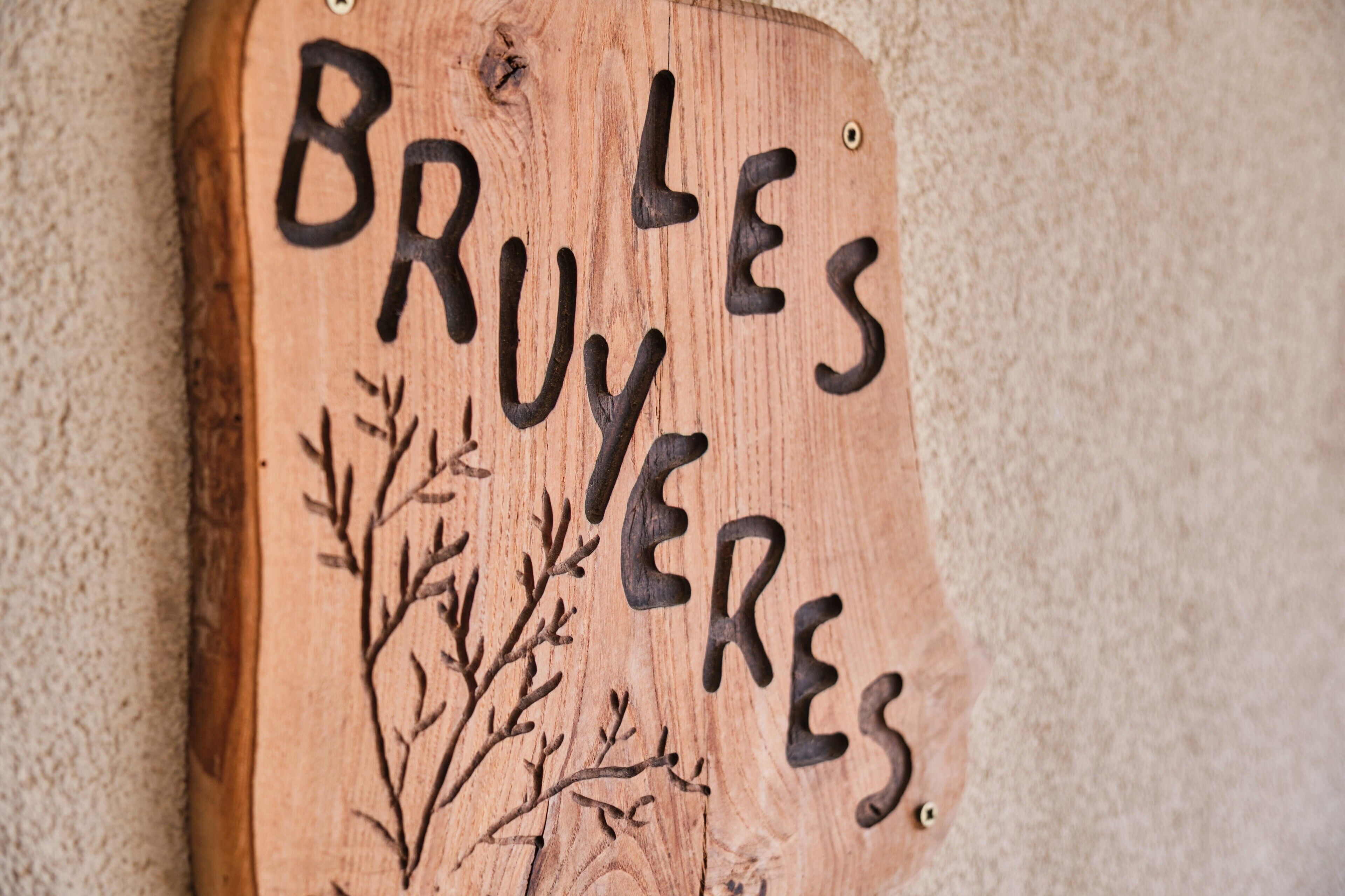 A wooden sign with the text 'BRUYS BRUYERES' and a tree illustration.