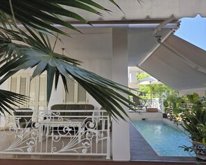A covered outdoor area with a pool, white railing, and potted plants. - Villa Dyrrahu (Golem)