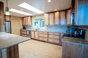 A modern kitchen with wooden cabinets, granite countertops, and a built-in oven.