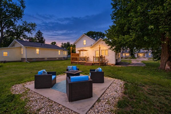 A residential area with a house featuring a deck and outdoor seating area.