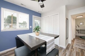 A dining area with a table, chairs, and a ceiling fan.