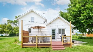 A single-story house with a front porch, a mailbox, and a small deck area.