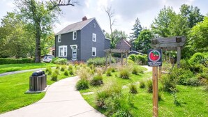 A residential area with a house, a pathway, and a sign for NatureWorks Investment. - Park-side family retreat with private backyard (University Heights)