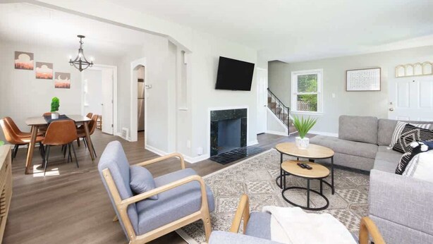 A spacious living room with a fireplace, a dining area with a table and chairs, and a seating area with a sofa and armchairs. - Park-side family retreat with private backyard (University Heights)