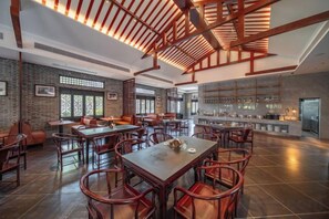 A spacious restaurant with high ceilings, exposed beams, and a variety of seating arrangements including tables and chairs. - Longquan Xiangyuan Shared Farm (Wenchang)