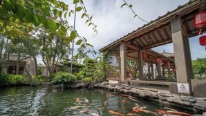A koi pond with a wooden pavilion and stone walls. - Longquan Xiangyuan Shared Farm (Wenchang)