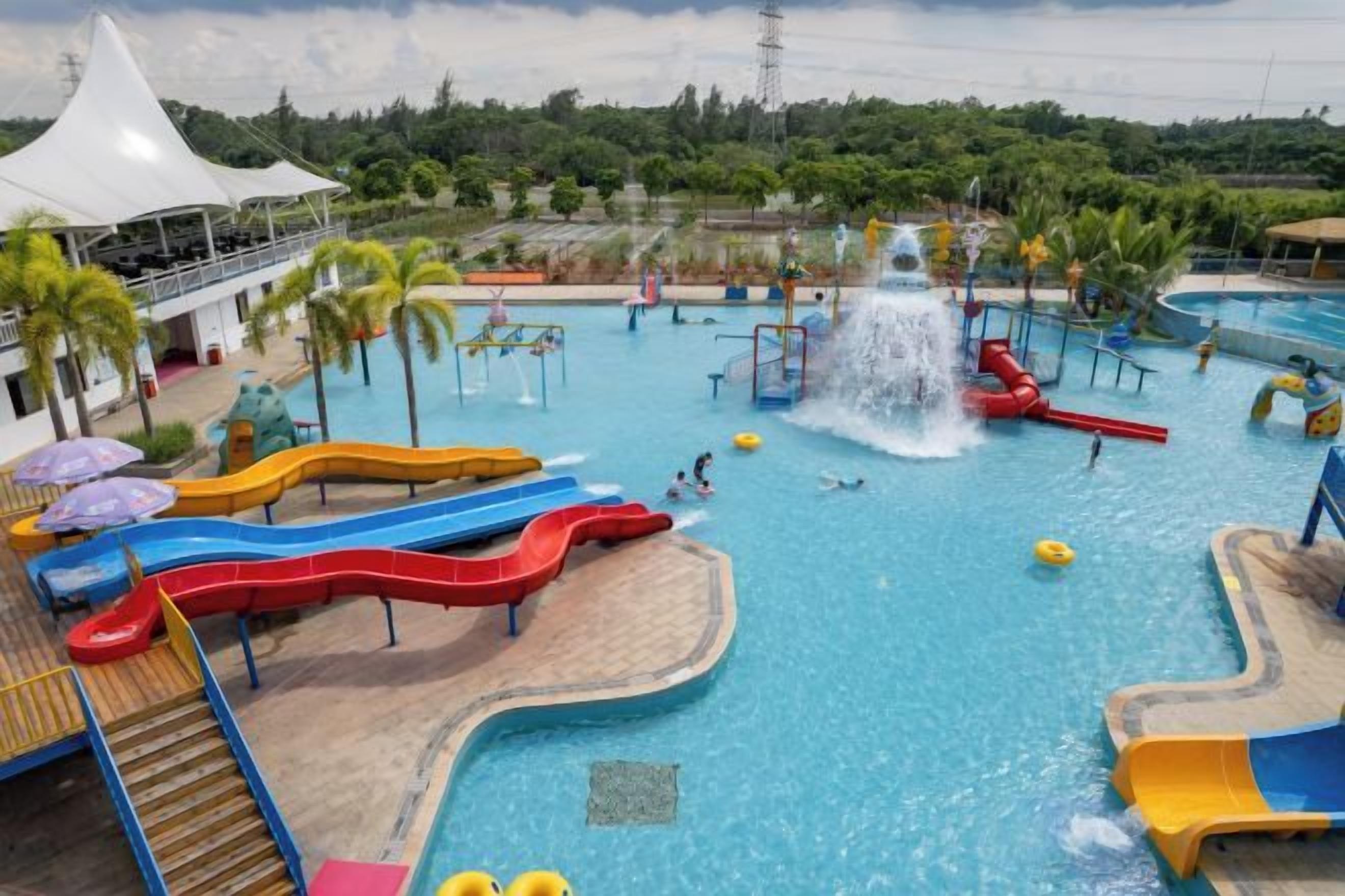 Un parque acuático con múltiples toboganes y una fuente central de agua.