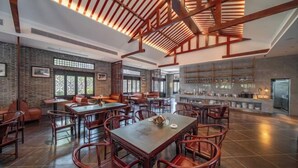 A spacious restaurant with high ceilings, exposed wooden beams, and a modern kitchen area. - Longquan Xiangyuan Shared Farm (Wenchang)