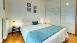A bedroom with a bed, bedside tables, a radiator, and wall decorations. - CaseOspitali - CASA CERTOSA pochi min da Rho Fiera (Milan)