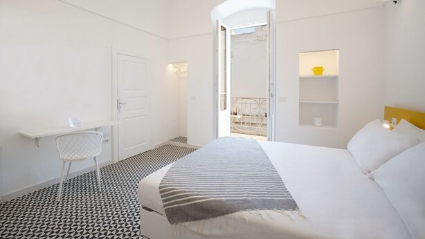 Una habitación de hotel moderna con una cama, un escritorio y una silla.