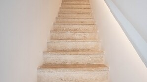 Una escalera de hormigón con una pared blanca a un lado y un techo blanco al otro.